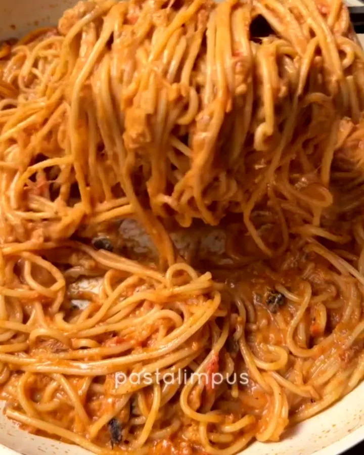 Twirled spaghetti with creamy eggplant sauce, garnished with fresh basil leaves