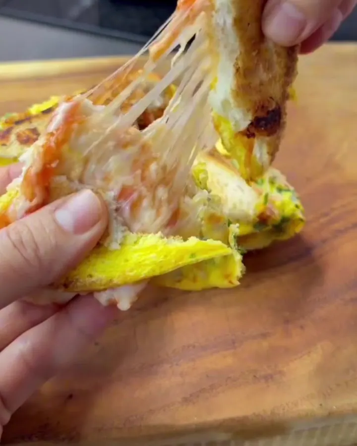 Golden crispy sandwich pulled apart showing melted cheese and sucuk
