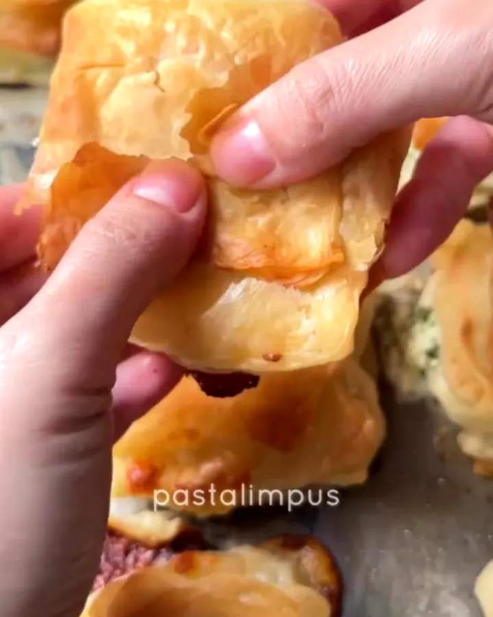 Golden crispy layered börek with melted cheese on a baking sheet