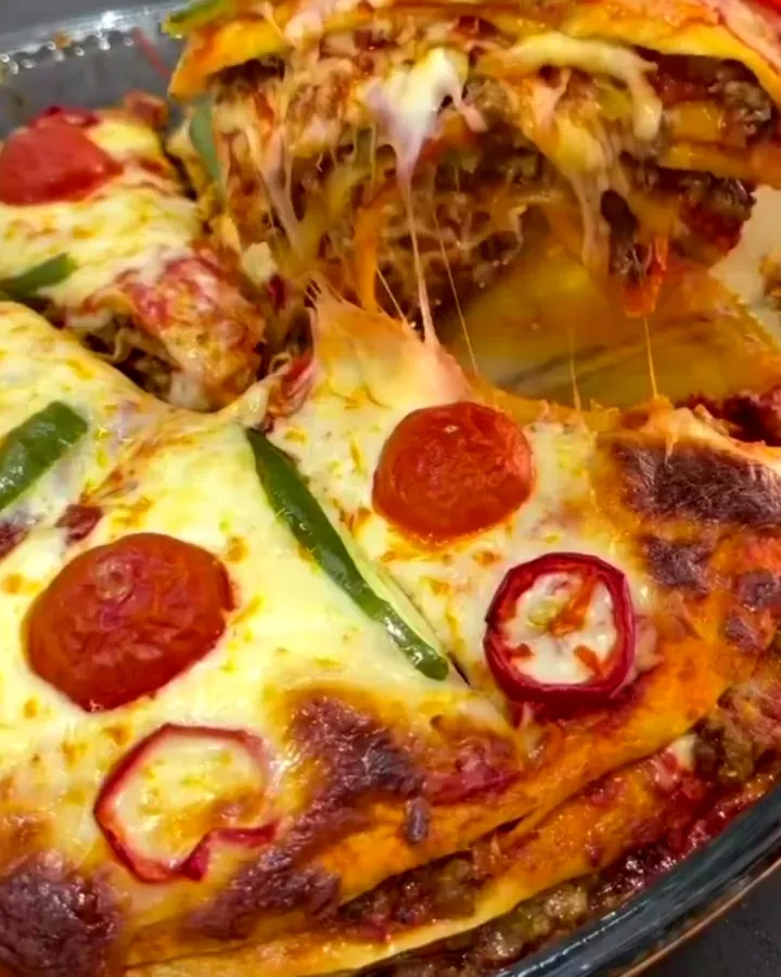 Thick wedge of layered lavaş pizza pie with melted mozzarella stretching between layers