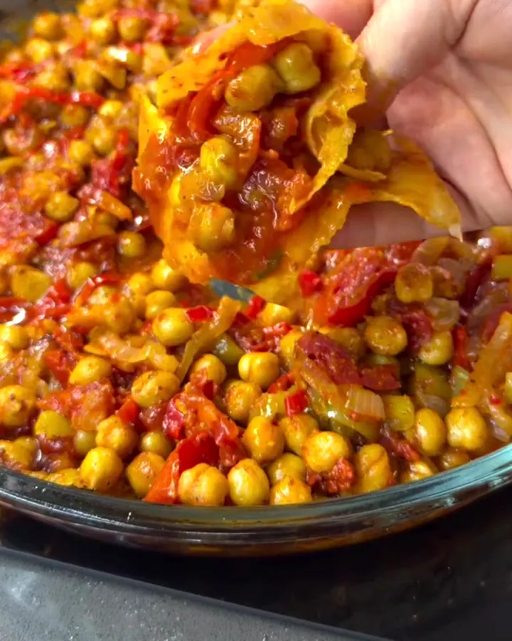 A tight dürüm wrap filled with roasted chickpeas and spiced vegetables, cut in half showing the colorful filling.