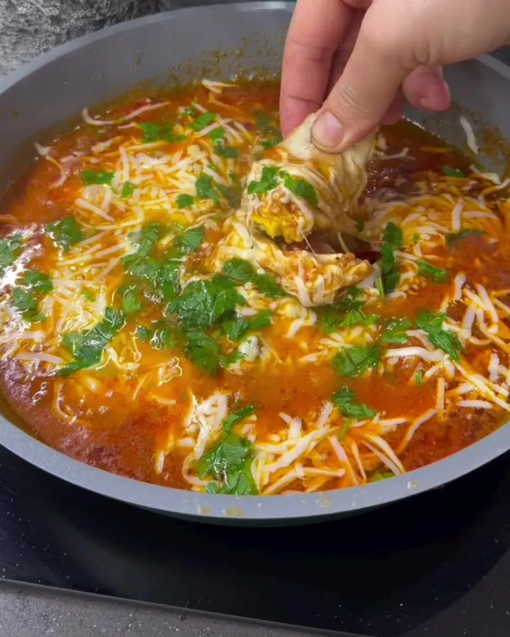 Skillet with melted cheese and peppers, bread tearing dip