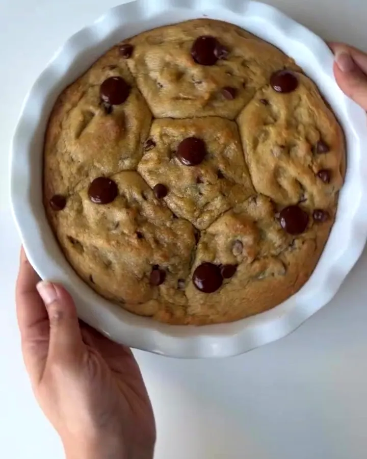Giant chocolate chip cookie broken open with molten Nutella flowing out