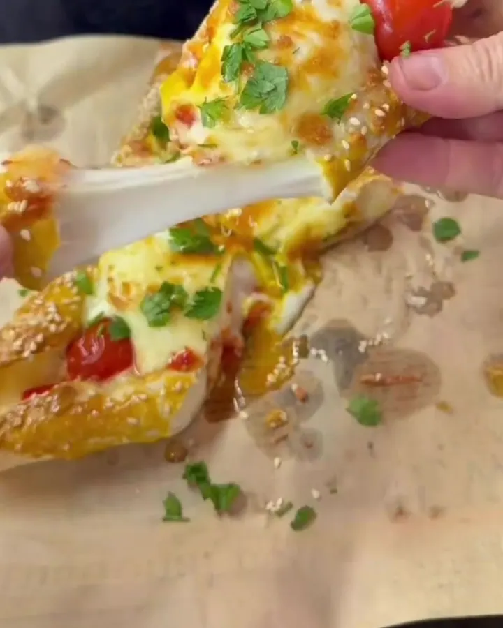 Hot baked lavaş boat sliced in half with cheese pull and golden yolk